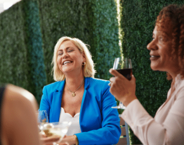 Two women smiling in a team building space at ICONA Avalon