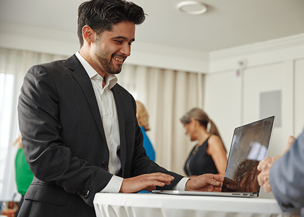 Business man looking at his laptop in a board meeting venue